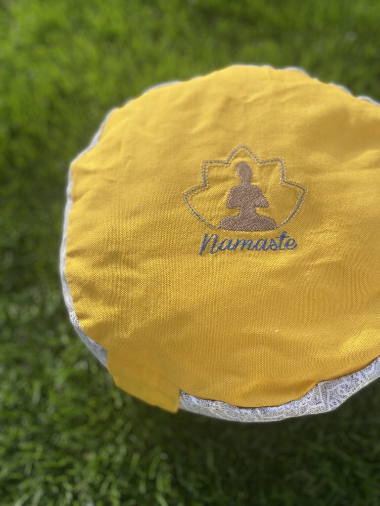 Namaste auf gelbem Meditationskissen